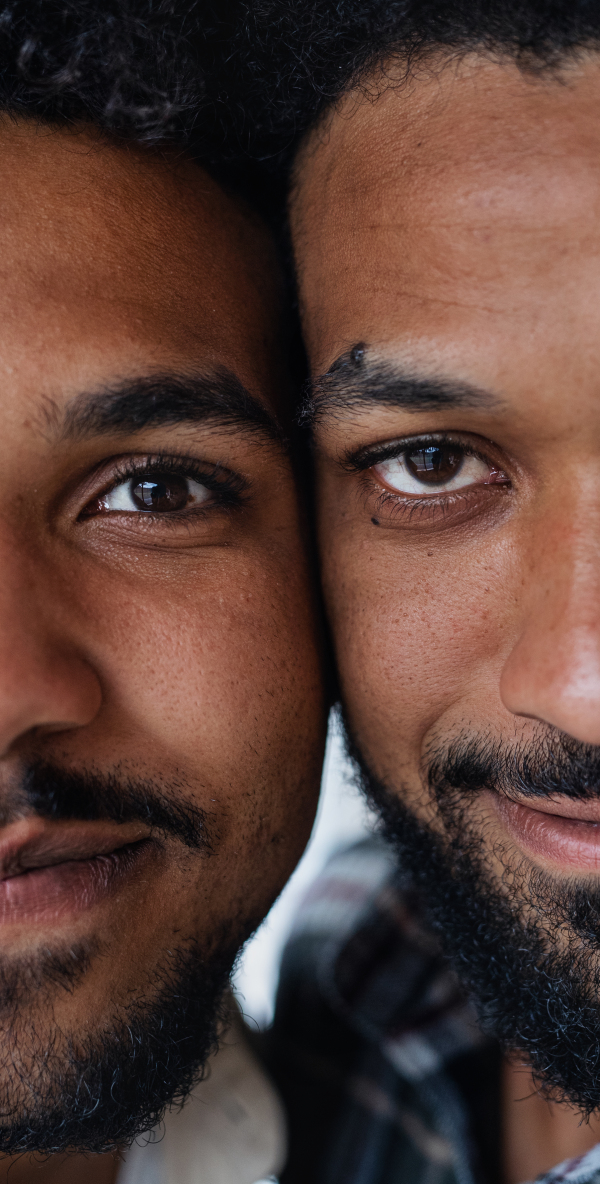 Close-up front view portrait of young adult brothers looking at camera.