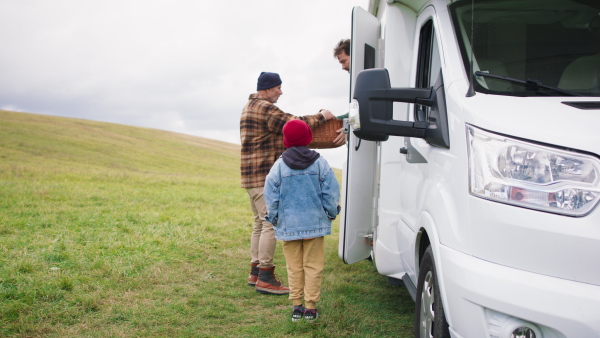 Three generations men spending time together during camping in camper van at autumn nature.