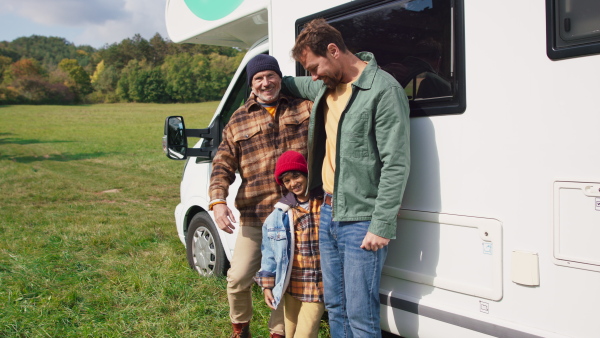 Three generations men spending time together during camping in camper van at autumn nature.