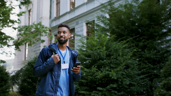 A man caregiver, male nurse or healthcare worker with smartphone on the way to work.