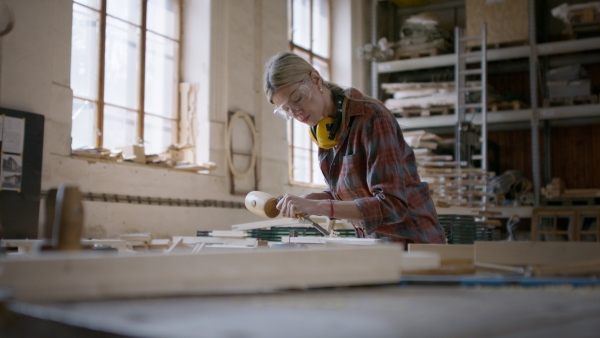 A female carpenter working on her product. Small business concept.