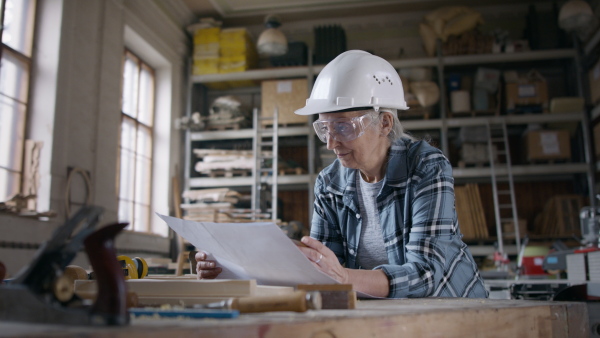 A senior female carpenter sketching desing of his product. Small business concept.