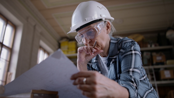 A senior female carpenter sketching design of her product. Small business concept.