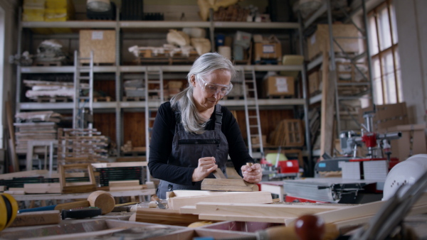 A senior female carpenter working on her product. Small business concept.