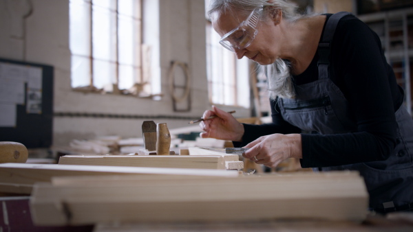 A senior female carpenter working on her product. Small business concept.