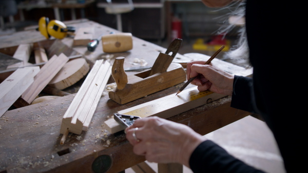 A close up of senior female carpenter working on her product. Small business concept.