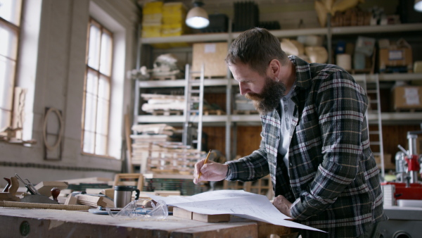 A male carpenter sketching desing of his product. Small business concept.