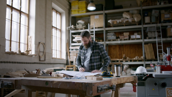 A male carpenter sketching desing of his product. Small business concept.