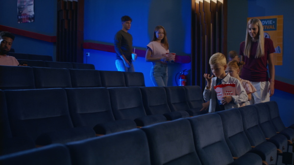 A large group of people getting ready for movie in the cinema.