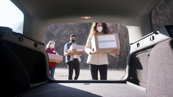 Group of volunteers in community donation center delivering meals. Food bank and coronavirus concept.