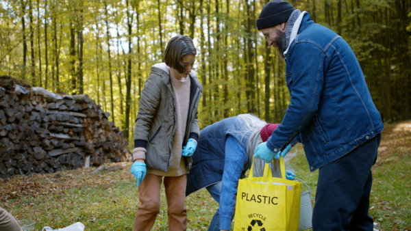 A diverse group of volunteers cleaning up forest from waste, community service concept