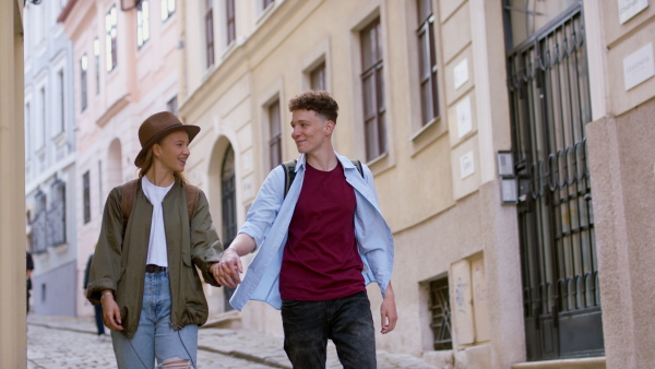 A young couple travelers walking in city on holiday, sightseeing.