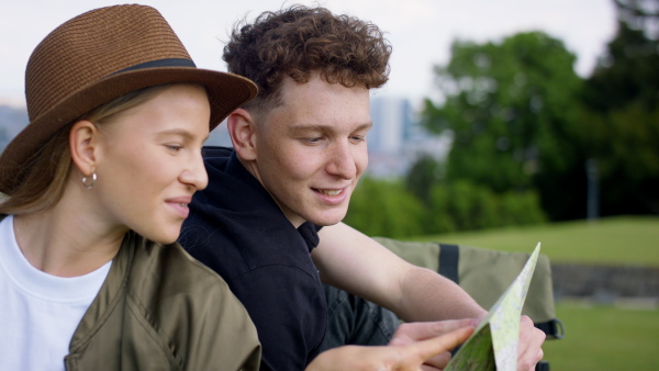 Young couple travelers walking with map in city on holiday, sightseeing.