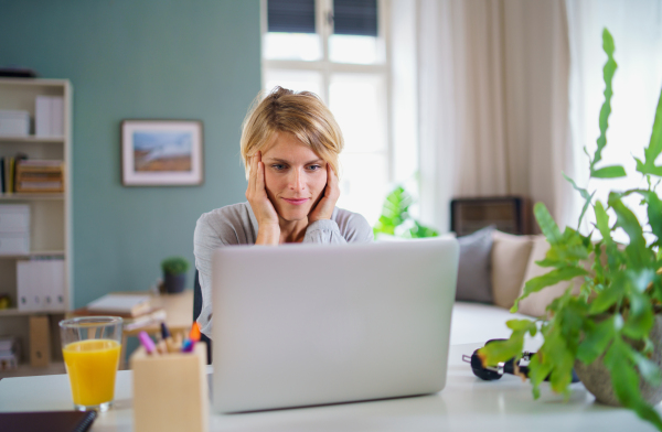 Portrait of happy business woman working indoors in office at desk, home office concept.