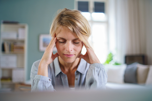 Portrait of calm business woman meditating indoors in office at desk, mental health concept.