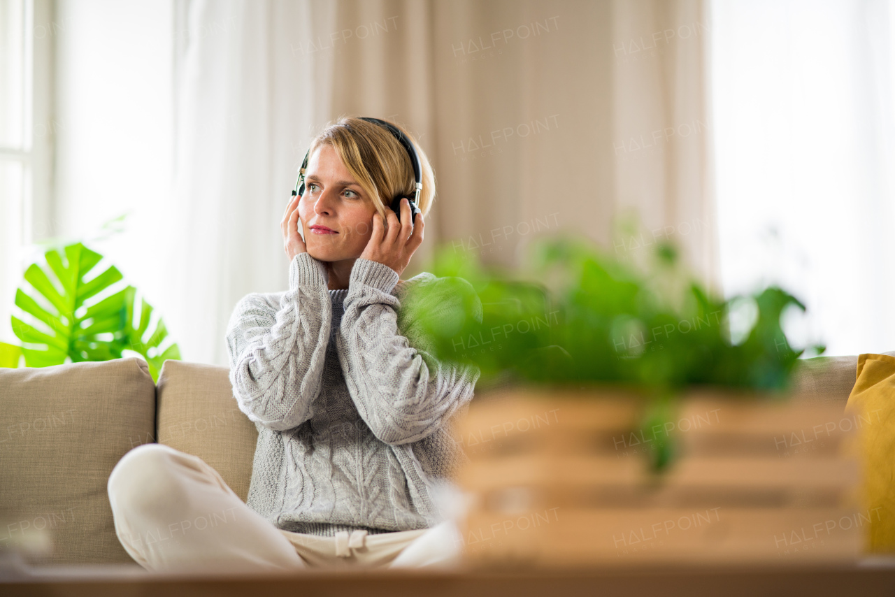 Top view portrait of woman with headphones relaxing indoors at home, mental health care concept.