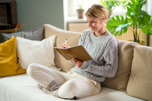 Front view portrait of woman relaxing indoors at home, mental health care concept.