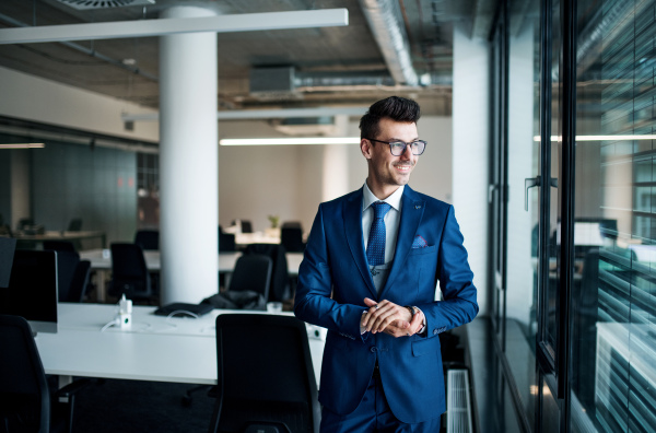 A portrait of young businessman standing in an office. Copy space.