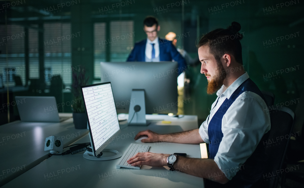 Two young businessmen with desktop computer in an office, working.