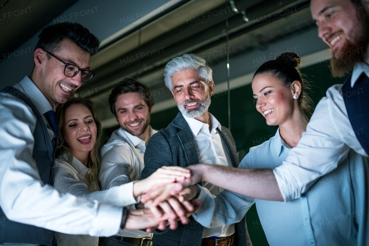 A group of business people with computer in an office in the evening, expressing excitement.