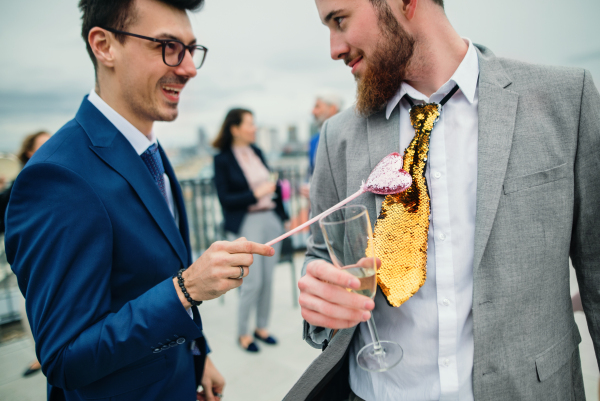 A large group of joyful businesspeople having a party outdoors on roof terrace in city.