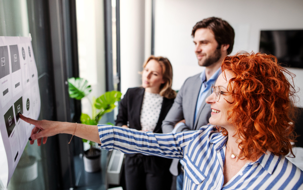 A group of young business people talking in an office, brainstorming.