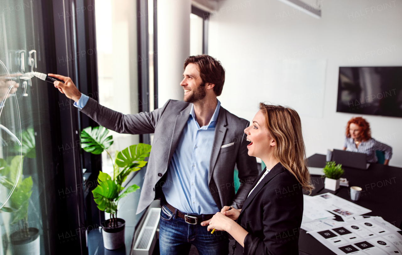 A group of young business people talking in an office, brainstorming.