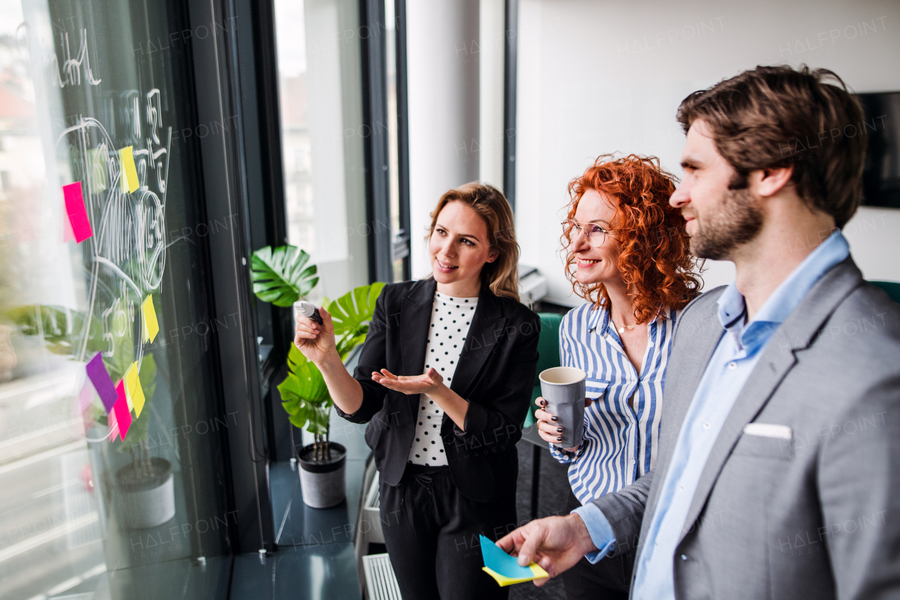 A group of young business people talking in an office, brainstorming.