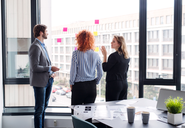 A group of young business people talking in an office, brainstorming.