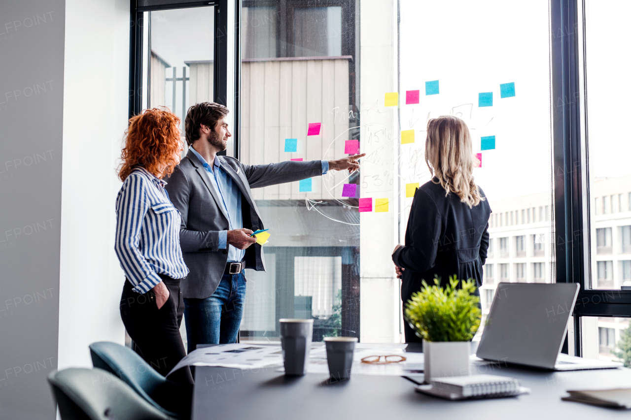 A group of young business people talking in an office, brainstorming.