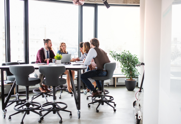 A group of young business people sitting in an office, having meeting.