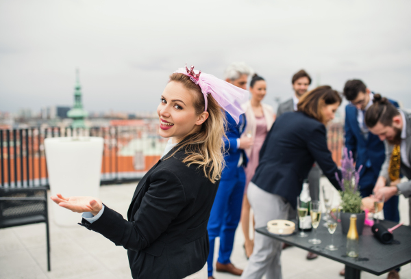 A large group of joyful businesspeople having a party outdoors on roof terrace in city.