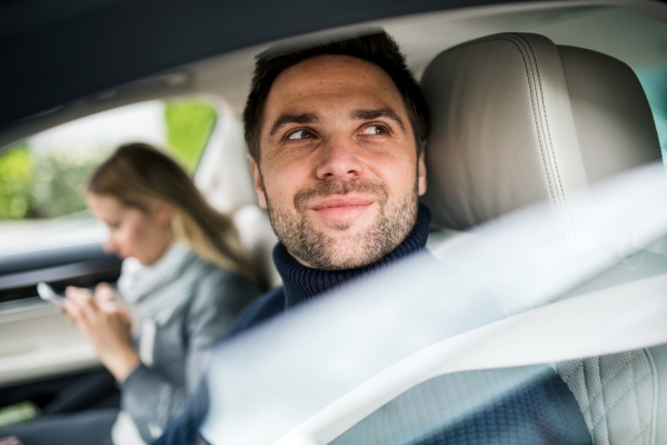 A young couple sitting in a car, driving.