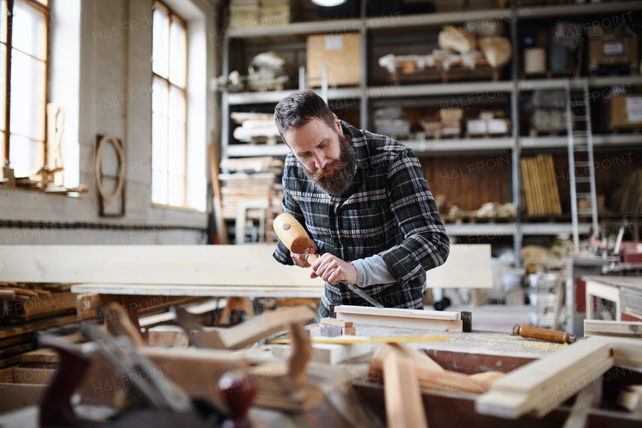 A portrait of mature male carpenter working on his product. Small business concept.