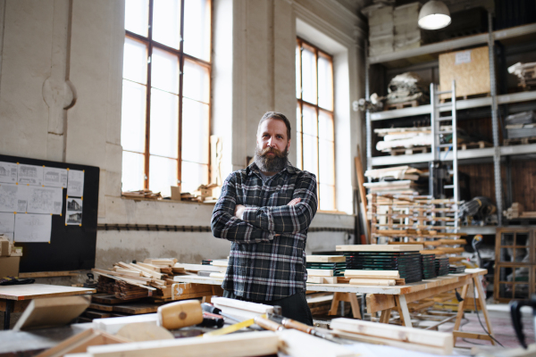 A portrait of mature male carpenter working on his product. Small business concept.