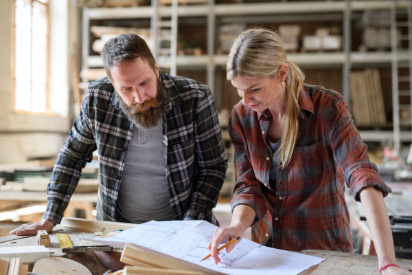 Two carpenters a man and a woman talking about design of products. Small business concept.