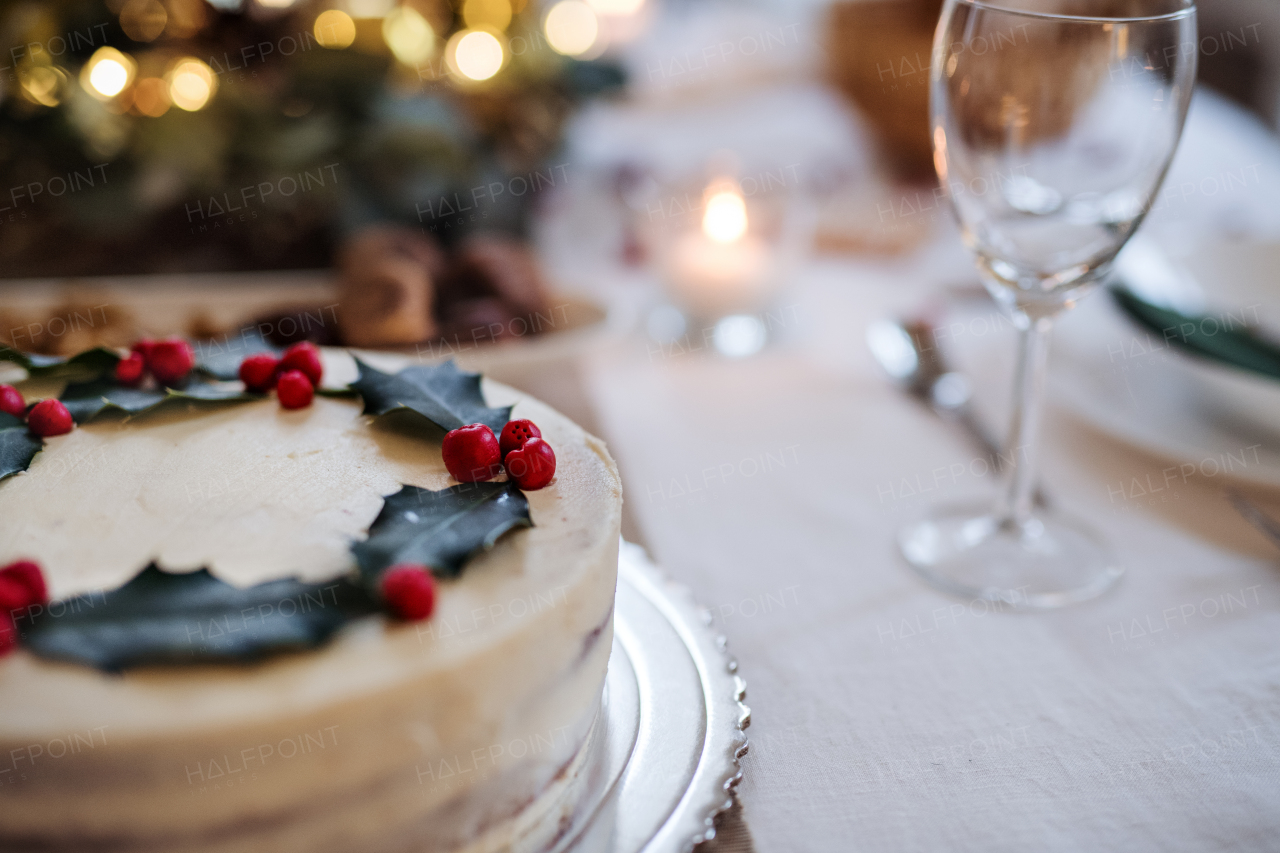 A close-up of cake on table set for dinner meal at Christmas time. Copy space.