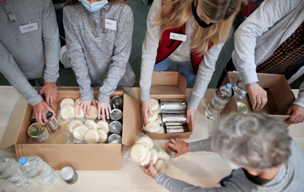 Top view of group of volunteers working in community charity donation center, food bank and coronavirus concept.