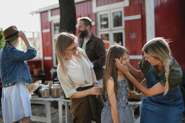 A happy girl with her mother meeting her aunt at local family farmers market.