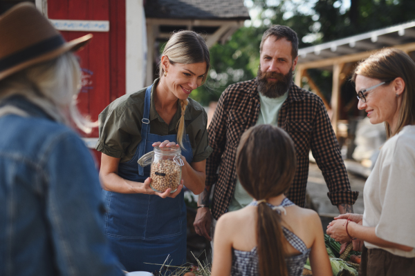 A little girl buying organic vegetables outdoors at community farmers market.