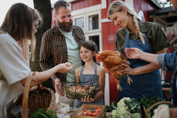 A happy womanl buying organic eggs outdoors at local family farmers market.