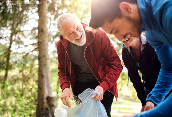 A group of active young people picking up litter in nature, a plogging concept.