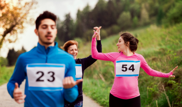 A group of active multi generation people running a race competition in nature.