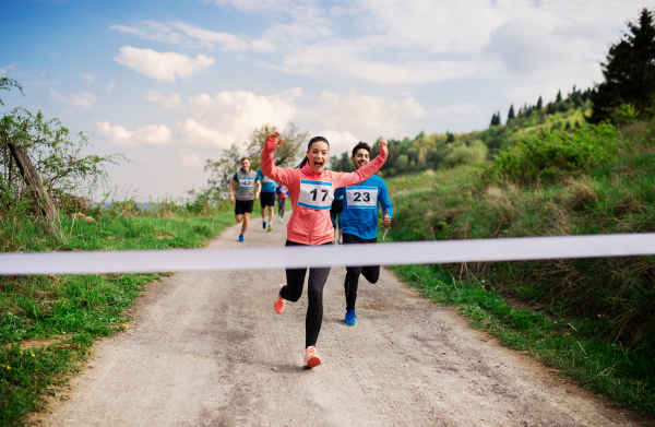 A large group of active people running a race competition in nature.