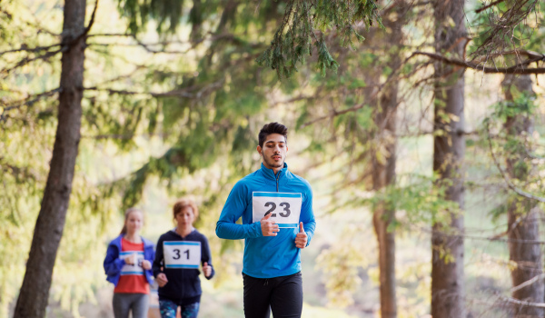 A group of active multi generation people running a race competition in nature.