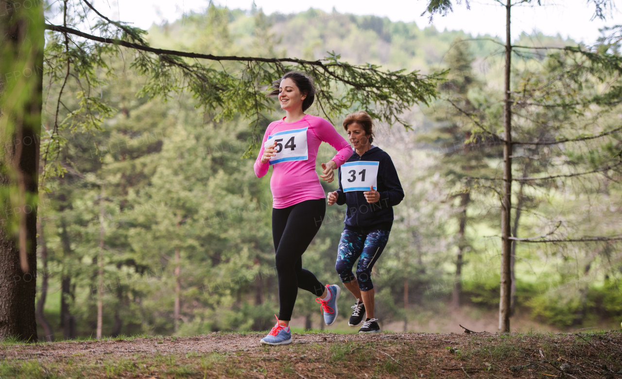 Beautiful pregnant woman running a race competition in nature.