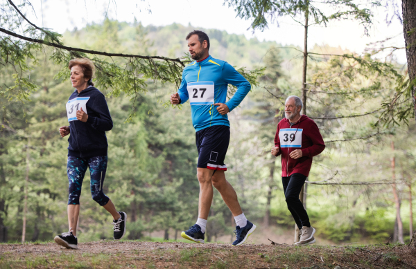 A group of active multi generation people running a race competition in nature.