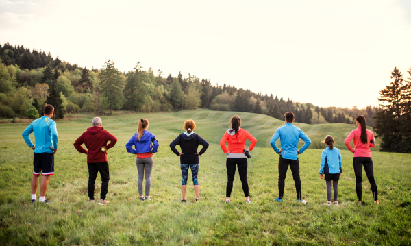 A large group of active multi generation people running a race competition in nature, resting.