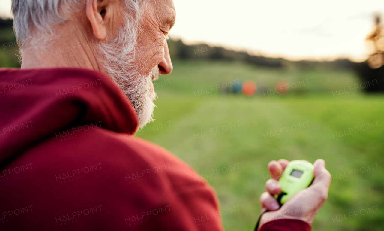 A close-up portrait of man checking time when doing exercise in nature.