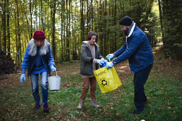 A diverse group of volunteers cleaning up forest from waste, community service concept